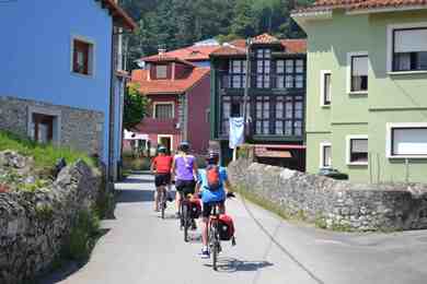 cycling between pastle colours painted houses near Llanes